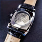 Alcom Distribution men's mechanical square watch showing silver case and visible gears with black leather strap