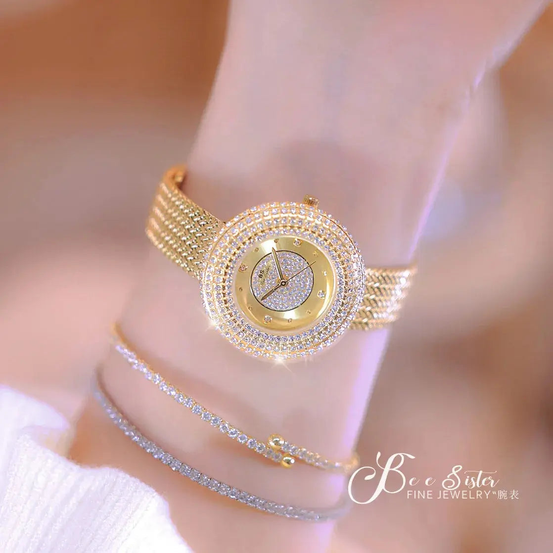 Alcom Distribution gold crystal round watch on wrist with mesh band and layered bracelets hot-selling ladies quartz watch