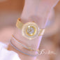 Alcom Distribution gold crystal round watch on wrist with mesh band and layered bracelets hot-selling ladies quartz watch