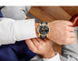 CARNIVAL men's automatic watch gold case black dial leather strap on wrist with white shirt and suit