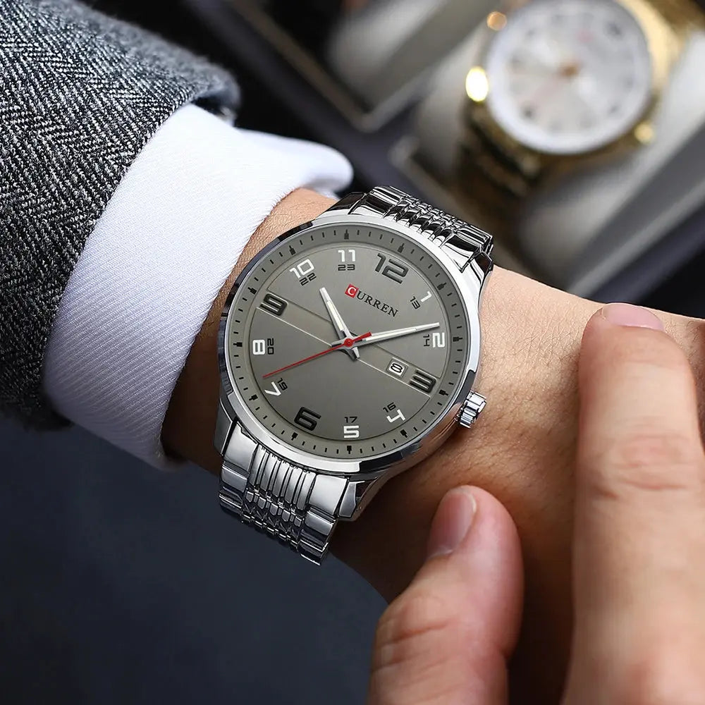 Stainless steel business watch by Alcom Distribution worn on wrist with grey dial and metal band