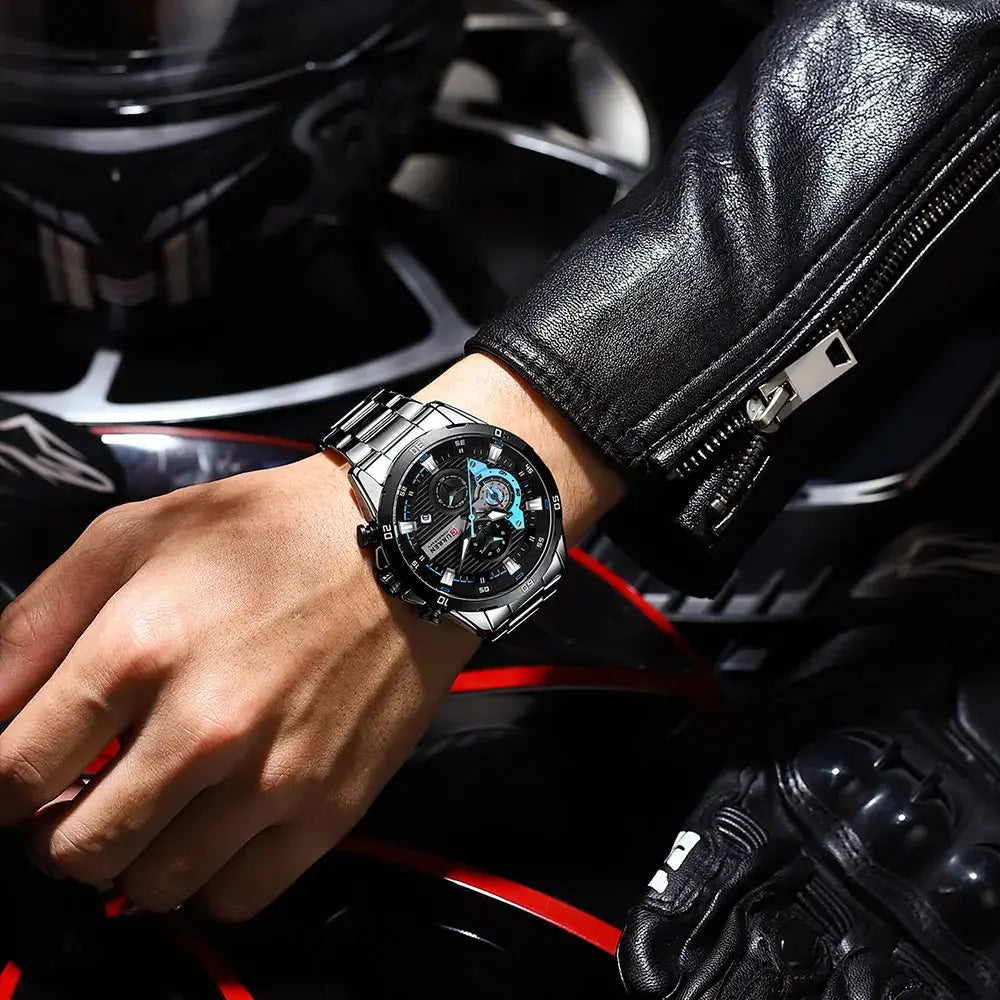 CURREN stainless steel watch on wrist with black and blue dial worn with black leather jacket and motorcycle gear