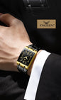Alcom Distribution FNGEEN black and gold rectangular dress luxury men's quartz watch on a suited wrist