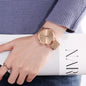 Hannah Martin rose gold watch with mesh band worn on wrist over blue sweater sleeve