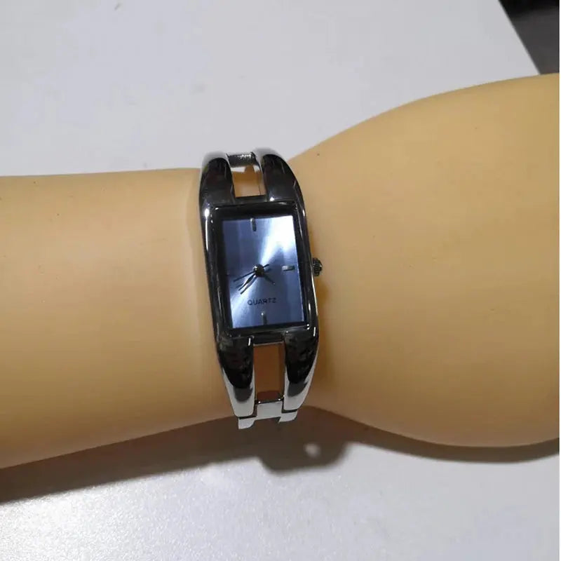 Alcom Distribution silver cuff bracelet watch on mannequin wrist luxury women's bracelet watch with rectangular blue dial