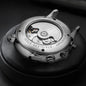 Luxury men's automatic watch back view showing stainless steel case and visible movement by Alcom Distribution