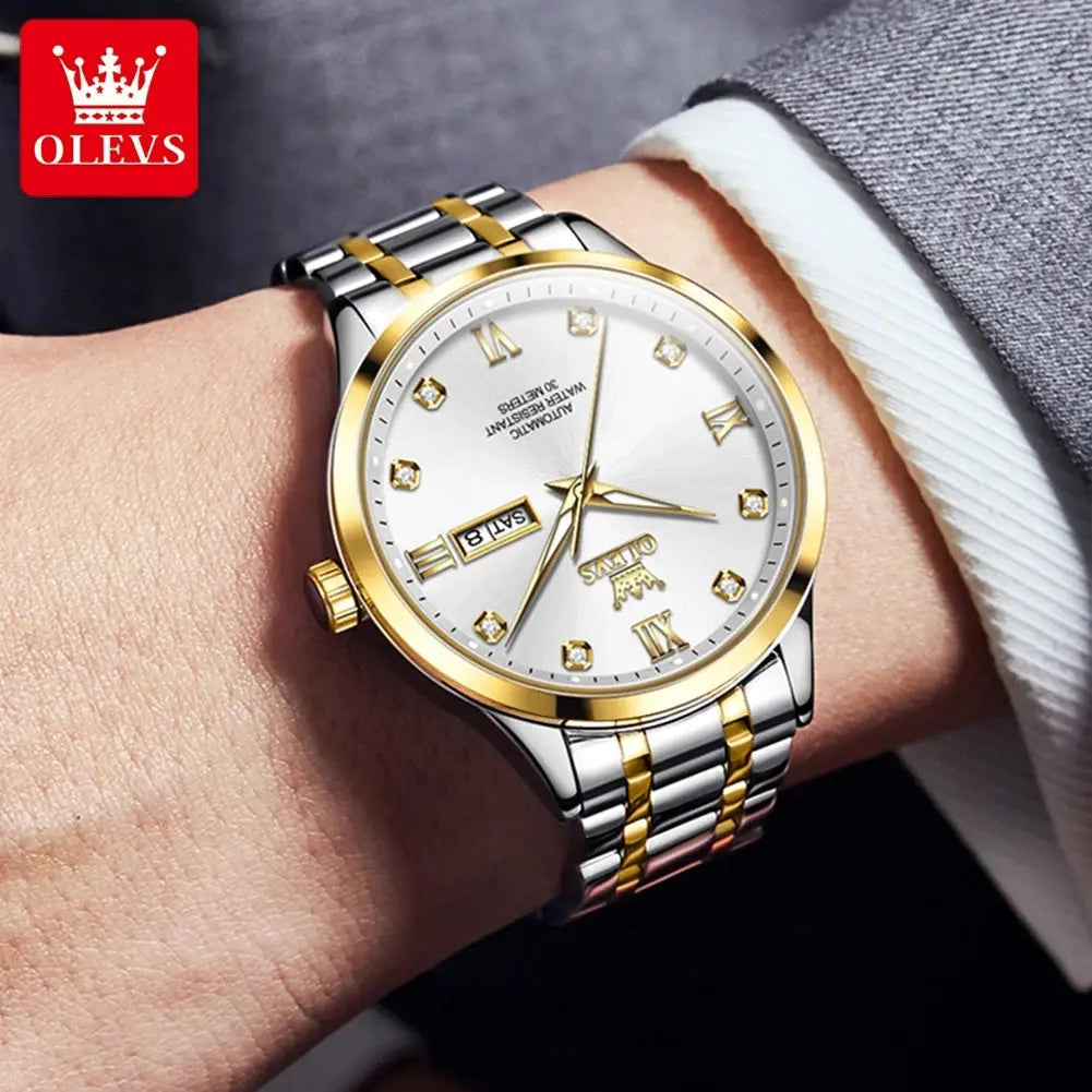 OLEVS diamond business watch in silver and gold tones on wrist with white dial and diamond hour markers