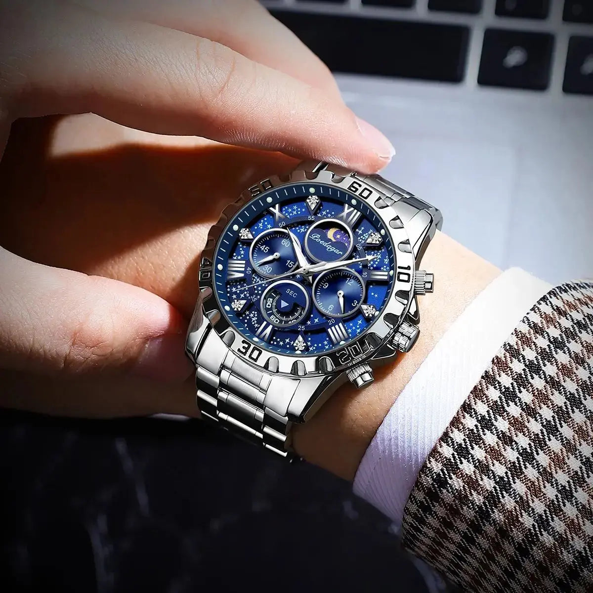 Fashionable men's luxury watch with silver metal band and blue dial worn on wrist