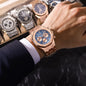 Alcom Distribution rose gold men's quartz chronograph watch with blue textured dial on wrist and suit cuff
