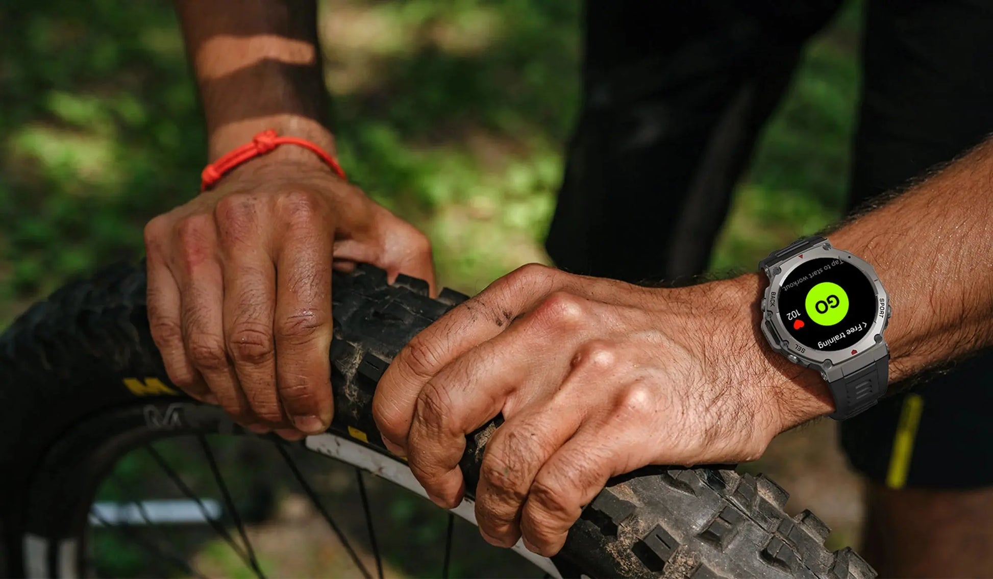 Alcom Distribution waterproof AMOLED display smartwatch on cyclist wrist repairing mountain bike tire outdoors