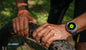 Alcom Distribution waterproof AMOLED display smartwatch on cyclist wrist repairing mountain bike tire outdoors