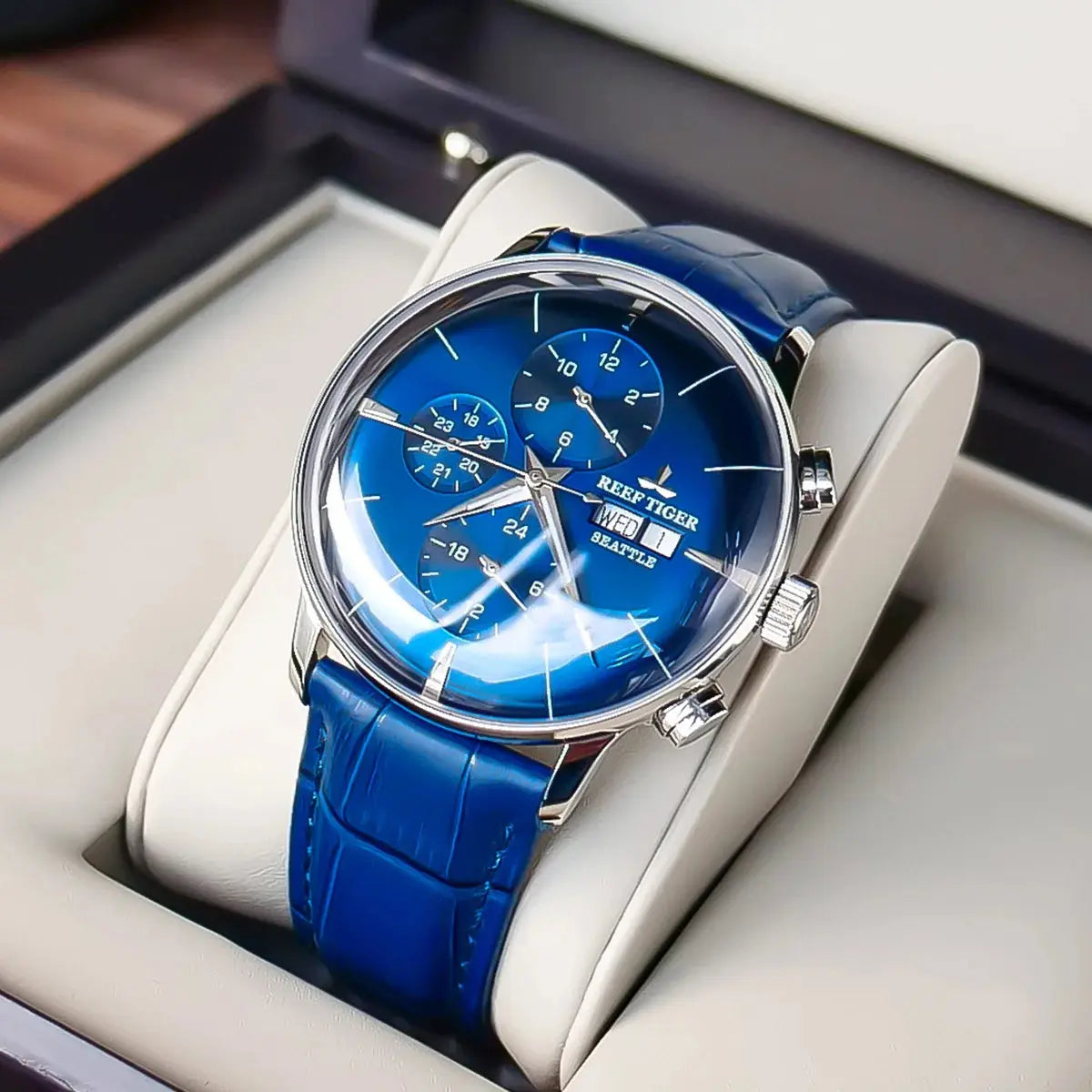 Reef Tiger luxury men's watch with blue dial and leather strap displayed in a beige watch case
