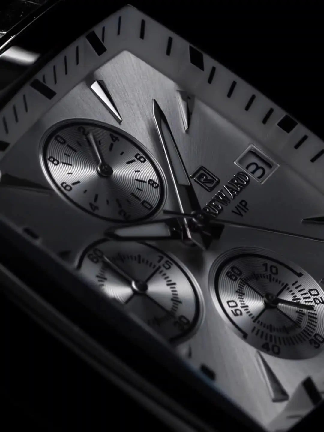 Close-up of men's blue rectangular watch with silver dial and chronograph features by Alcom Distribution