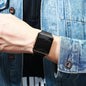 Alcom Distribution simple fashion digital watch black square face with gold bezel on wrist wearing denim jacket