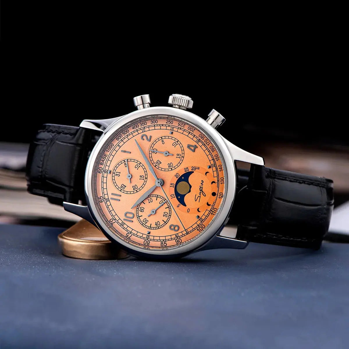 Sugess mechanical chronograph watch with orange dial, moon phase, stainless steel case, and black leather strap