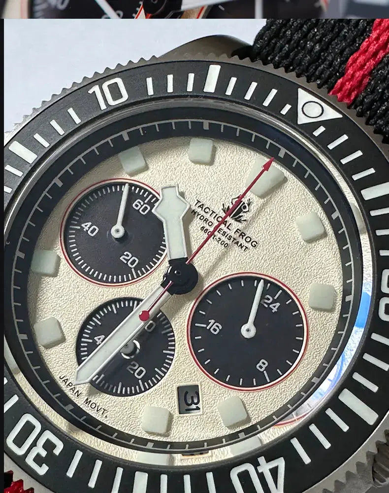Close-up of a titanium diving watch with black and red band and chronograph features
