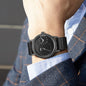 Minimalist men's leather watch with black dial and strap by Alcom Distribution worn on wrist