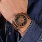 Alcom Distribution unisex wooden watch with brown wooden band and carved dial on wrist