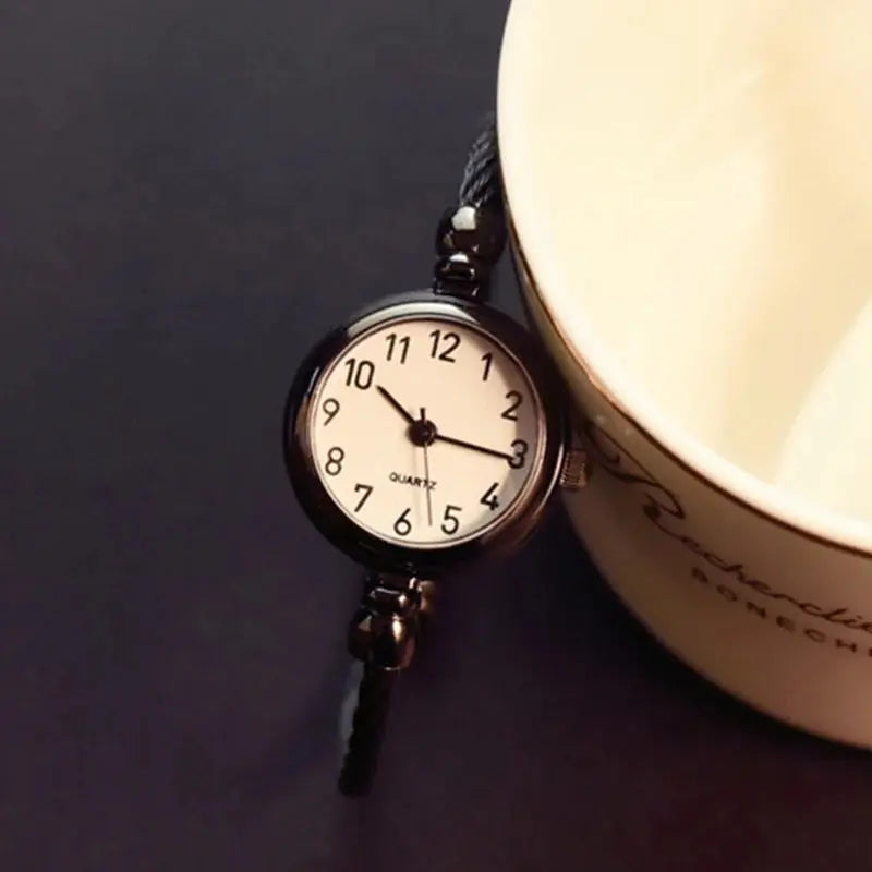 Alcom Distribution retro gold bangle watch with round white dial and black braided strap