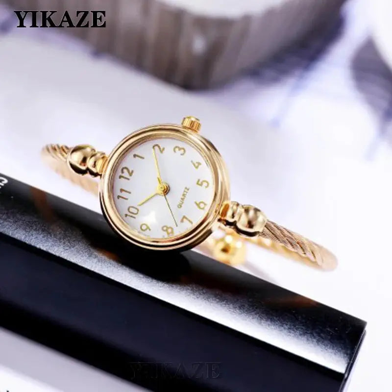 Alcom Distribution retro gold bangle watch with round face and gold dial on twisted band
