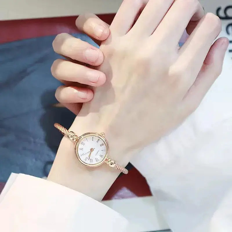 Alcom Distribution retro gold bangle watch worn on wrist with white dial and elegant design