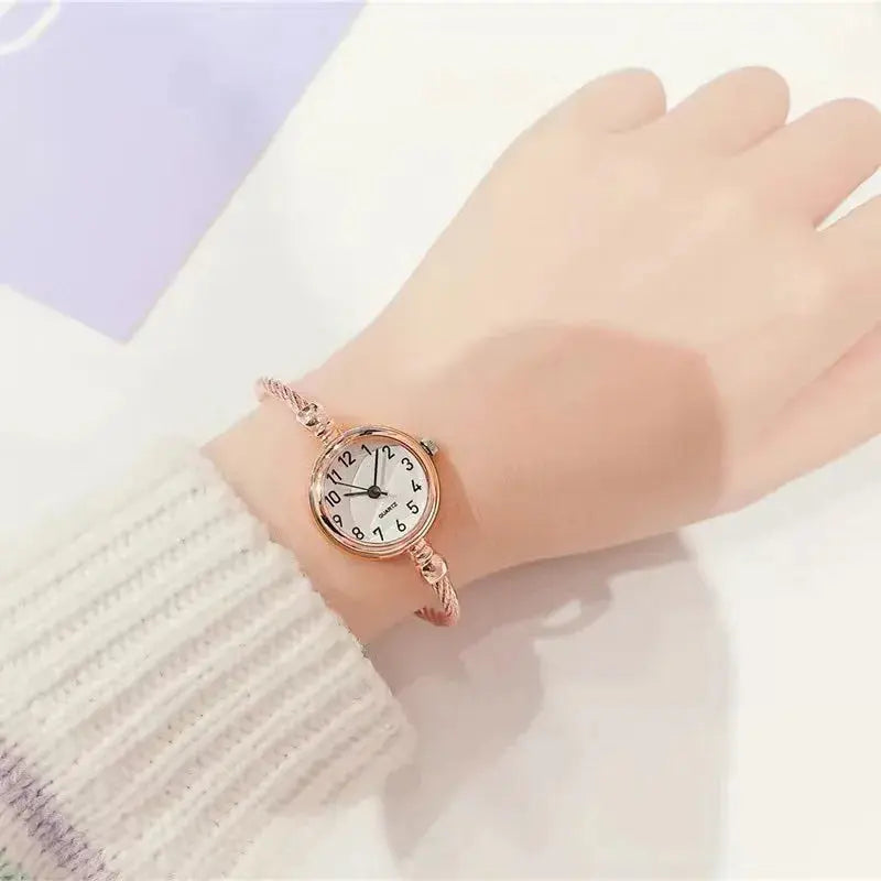 Retro gold bangle watch with a round white dial on wrist from Alcom Distribution