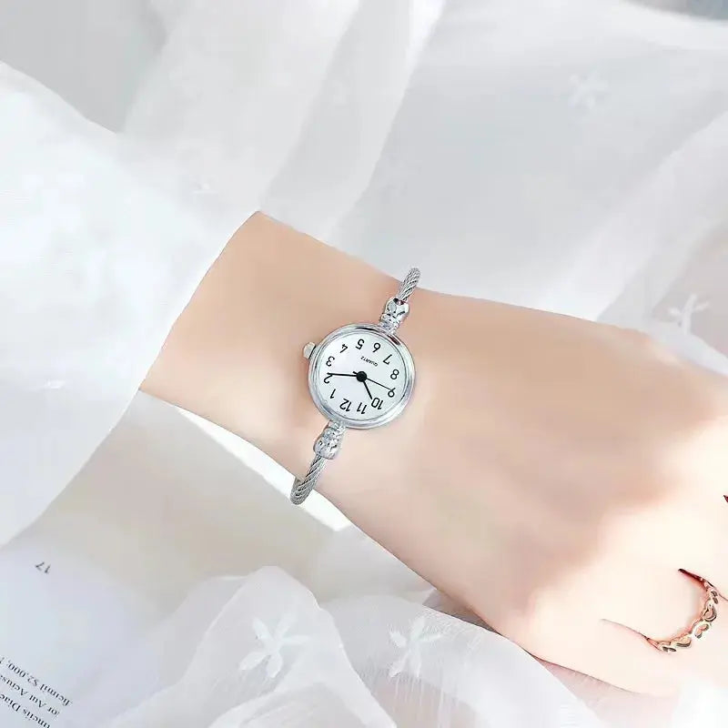 Alcom Distribution retro gold bangle watch with silver band worn on wrist