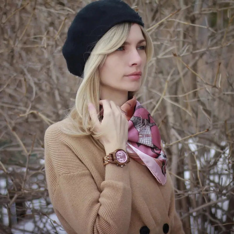 Woman wearing an eco-friendly bamboo watch from Alcom Distribution with a pink scarf and black beret