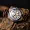 Luxury wooden mechanical watch with visible gears and brown wooden strap on rustic wood