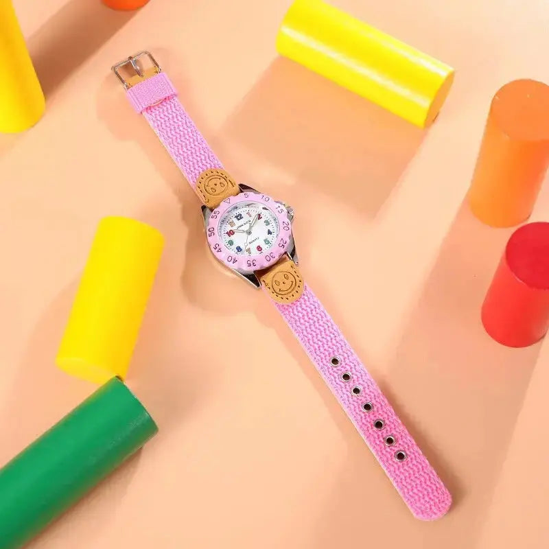 Alcom Distribution kids quartz watch colorful pink strap with smiley face design on a beige background