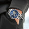 Glenaw rotating earth watch with silver band and blue starry dial worn on wrist by Alcom Distribution