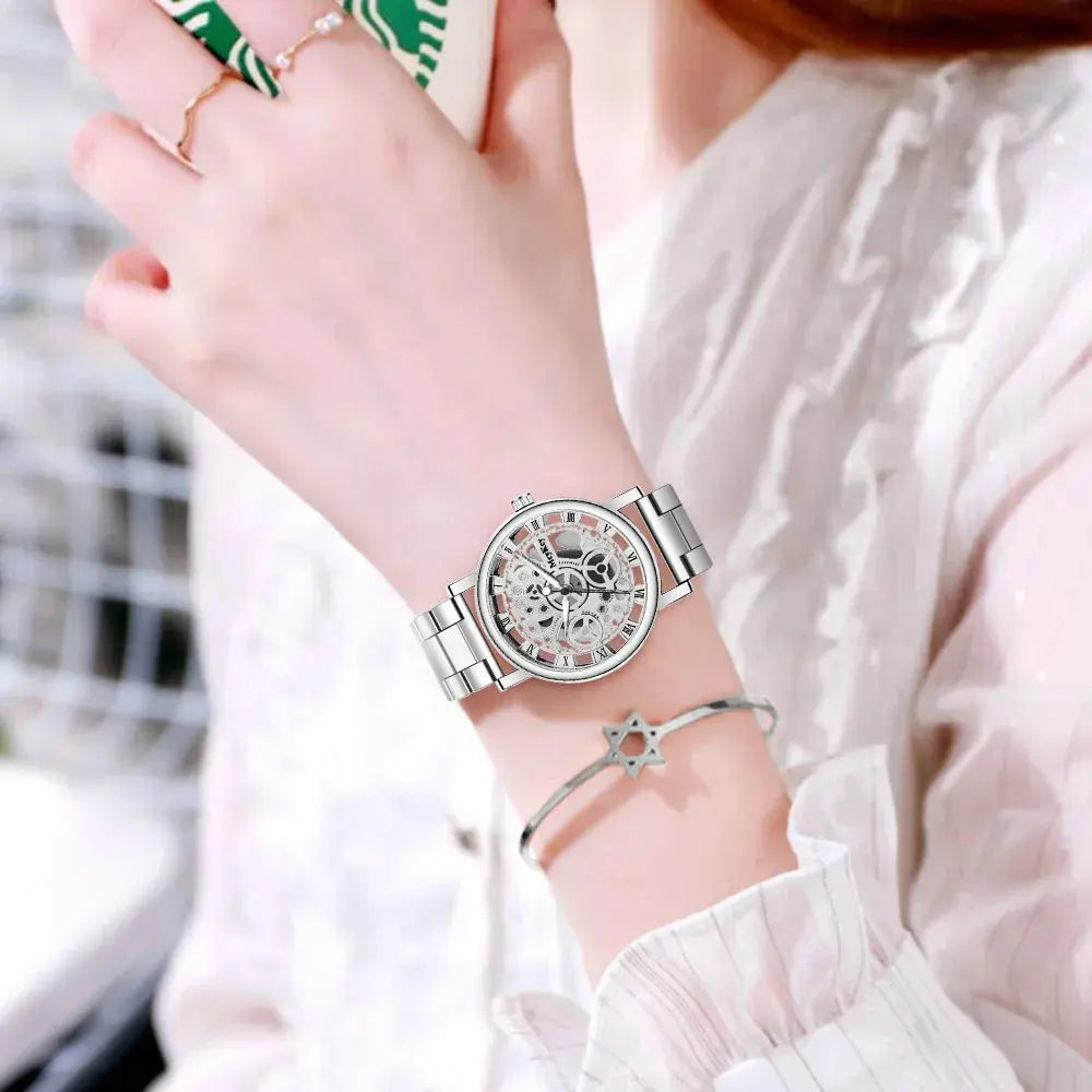 Silver Hollow Skeleton Quartz Watch with metal band worn on wrist by person in white blouse