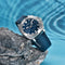 Pagani Design diver watch with blue dial and fabric strap displayed on a rock near water