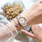 Luxury quartz watch for women with silver and rose gold band worn on wrist with delicate bracelet