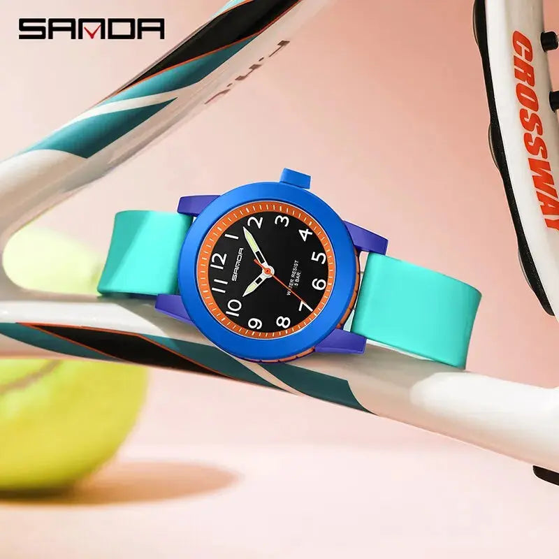 Children's shock resistant watch by Alcom Distribution with blue and turquoise strap on tennis racket