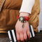 Shourui quartz wristwatch for women with red braided strap and leaf charm on wrist by Alcom Distribution